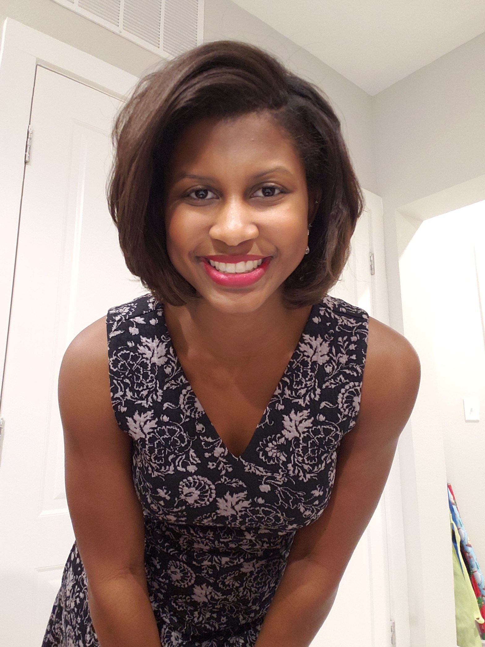 Jalynn smiling with red lipstick, short haircut, and happy